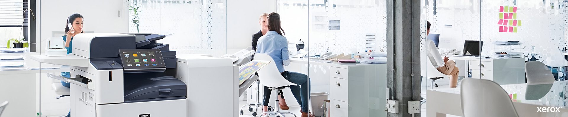 Un ufficio spazioso con una stampante Xerox® e un computer su una scrivania, che mostra un ambiente di lavoro professionale.