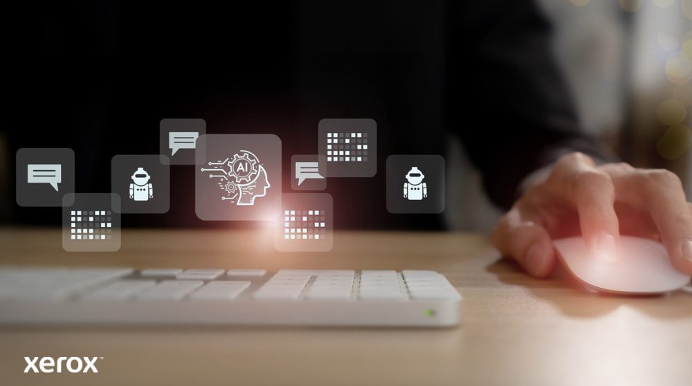 Xerox® DocuShare® Go: gestione intelligente dei documenti La mano di una persona è sul mouse di un computer, con icone astratte luminose legate alla comunicazione, all'intelligenza artificiale e all'elaborazione dei dati che fluttuano sopra la tastiera, rappresentando le funzionalità intelligenti dei documenti.