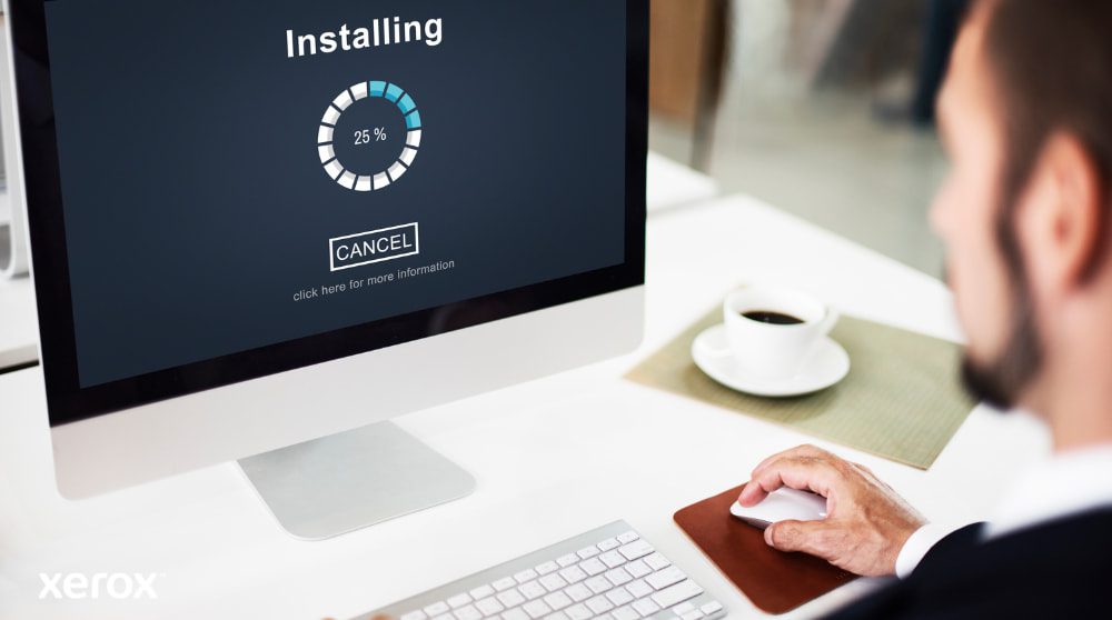 Primo piano di un monitor di computer che mostra una barra di avanzamento "Installazione" al 25%, con la mano di una persona sul mouse del computer accanto a una tazza di caffè, a dimostrazione della semplice configurazione del software.